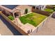 Aerial view of a fenced backyard featuring a well-maintained lawn and a covered patio at 25969 W Tina Ln, Buckeye, AZ 85396