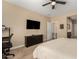 Bedroom with ceiling fan, dresser, and large TV at 25969 W Tina Ln, Buckeye, AZ 85396