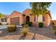 Front view of a one-story house with a brown facade, landscaping, and a two-car garage at 25969 W Tina Ln, Buckeye, AZ 85396