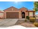 One-story home with brown exterior, two-car garage, and landscaped front yard at 25969 W Tina Ln, Buckeye, AZ 85396