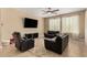 Living room with black leather furniture and a large TV at 25969 W Tina Ln, Buckeye, AZ 85396