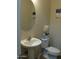 Small bathroom with pedestal sink, toilet, and oval mirror at 26035 W Quail Ave, Buckeye, AZ 85396