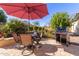 Backyard patio with dining table, grill, and umbrella at 26541 W Ross Ave, Buckeye, AZ 85396