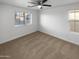 Well-lit bedroom with two windows, ceiling fan, and carpet at 2708 N Heritage St, Buckeye, AZ 85396