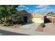 Single-story home with tan exterior, landscaped yard, and two-car garage at 27194 N Skipping Rock Rd, Peoria, AZ 85383