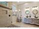 Elegant bathroom with glass shower, double vanity, and decorative mirrors at 30994 N 74Th Way, Scottsdale, AZ 85266