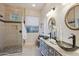 Elegant bathroom with glass shower, double vanity, and decorative mirrors at 30994 N 74Th Way, Scottsdale, AZ 85266