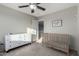 Bedroom with crib, dresser, and ceiling fan at 3496 E Anika Ct, Gilbert, AZ 85298