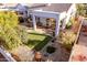 Elevated view of backyard with covered patio, lush lawn, and surrounding trees at 3818 N Lomond Cir, Mesa, AZ 85215