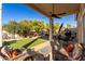 Covered patio with seating area, grassy lawn, and mature trees at 3818 N Lomond Cir, Mesa, AZ 85215