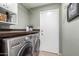 Functional laundry room with washer, dryer, and storage at 4009 W Cielo Grande Rd, Glendale, AZ 85310