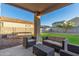 Inviting back patio featuring comfortable seating, a well-maintained yard and beautiful Arizona sunshine at 40561 W Hillman Dr, Maricopa, AZ 85138