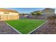 Grassy backyard with minimal landscaping, surrounded by block wall providing ample privacy at 40561 W Hillman Dr, Maricopa, AZ 85138