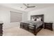 Cozy bedroom featuring a large bed frame, ceiling fan, and a window with lots of natural light at 40561 W Hillman Dr, Maricopa, AZ 85138