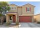 Two-story house with red garage door and landscaping at 40561 W Hillman Dr, Maricopa, AZ 85138