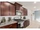 Well-equipped kitchen featuring dark wood cabinets and granite countertops at 40561 W Hillman Dr, Maricopa, AZ 85138