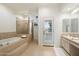 Luxurious bathroom with soaking tub, tiled shower, and vanity with stone countertop at 4430 N 22Nd St # 1, Phoenix, AZ 85016