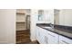 A bright bathroom features granite countertops, white cabinets, and a walk-in closet with custom shelving at 44512 N Sonoran Arroyo Ln, New River, AZ 85087