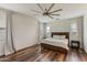 Primary bedroom with a large bed, wood floors, neutral tones, and large windows, creating a serene and inviting space at 44512 N Sonoran Arroyo Ln, New River, AZ 85087