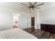 A spacious bedroom features wood floors, a ceiling fan and connects to the ensuite bathroom and walk-in closet at 44512 N Sonoran Arroyo Ln, New River, AZ 85087