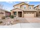 Inviting two-story home with a stone facade, paver driveway, and low-maintenance desert landscaping at 44512 N Sonoran Arroyo Ln, New River, AZ 85087