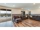 Bright living room opens to a pool, featuring wood-look floors and comfortable seating at 44512 N Sonoran Arroyo Ln, New River, AZ 85087