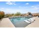 This backyard boasts a pool with tanning loungers, desert landscaping, a water feature, and mountain views at 44512 N Sonoran Arroyo Ln, New River, AZ 85087