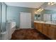 Elegant bathroom with double vanity, tiled floor, and bathtub at 5227 W Desperado Way, Phoenix, AZ 85083