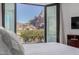 Comfortable bedroom with large glass doors leading to a private balcony and mountain view at 5655 N Camelback Canyon Dr, Phoenix, AZ 85018