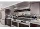 Modern kitchen features stainless steel appliances, dark cabinets, and a mirrored backsplash at 5655 N Camelback Canyon Dr, Phoenix, AZ 85018