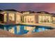 Inviting pool with in-pool seating reflects the home's modern lighting and sunset sky at 5655 N Camelback Canyon Dr, Phoenix, AZ 85018