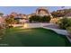 A view of the home's outdoor putting green with manicured landscaping and unique architectural design at 5655 N Camelback Canyon Dr, Phoenix, AZ 85018