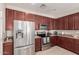 Modern kitchen featuring stainless steel appliances and rich wood cabinets at 5856 E Hampton Ave, Mesa, AZ 85206