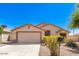 Tan house with a two-car garage and nicely landscaped yard at 603 W Sierra Vista Dr, Apache Junction, AZ 85120