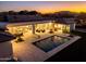 Aerial shot highlighting the property's pool, outdoor living space, and stunning mountain views at sunset at 6614 E North Ln, Paradise Valley, AZ 85253