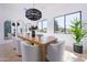 Elegant dining room with stylish lighting, a large wooden table, and views of the lush outdoor landscape at 6614 E North Ln, Paradise Valley, AZ 85253