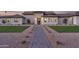 Inviting single-story home featuring a stone facade, manicured landscaping, and a walkway leading to the front door at 6614 E North Ln, Paradise Valley, AZ 85253