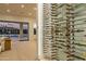 Modern wine cellar with custom racks and glass enclosure, complemented by an open living area at 6614 E North Ln, Paradise Valley, AZ 85253