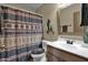 Neat bathroom with patterned shower curtain and wood vanity at 6863 E Haven Ave, Florence, AZ 85132