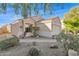 Tan house with a two-car garage and desert landscaping at 6863 E Haven Ave, Florence, AZ 85132