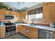 Cozy kitchen featuring stainless steel appliances and wood cabinets at 6863 E Haven Ave, Florence, AZ 85132