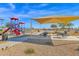 Community playground with play structures, shaded seating, and sandy play area at 6863 E Haven Ave, Florence, AZ 85132