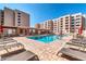 Community pool with surrounding lounge chairs and building view at 7940 E Camelback Rd # 506, Scottsdale, AZ 85251