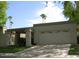 Tan two-car garage with covered entryway and mature landscaping at 8013 N Via Palma St, Scottsdale, AZ 85258