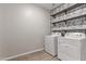 Bright laundry room with washer, dryer, and stylish shelving at 815 S 151St Ln, Goodyear, AZ 85338