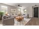 Cozy living room with neutral colors, plush seating, ceiling fan, and natural light at 815 S 151St Ln, Goodyear, AZ 85338