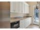 Butler's pantry with white shaker cabinets, granite countertops, and built-in microwave at 8220 N 15Th Ave, Phoenix, AZ 85021