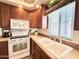 Bright kitchen with ample wood cabinets, white appliances, and a double sink at 840 S Aquamarine Dr, Apache Junction, AZ 85119