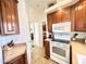 Kitchen with wood cabinets, white appliances, and a view to hallway at 840 S Aquamarine Dr, Apache Junction, AZ 85119