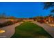 Landscaped backyard with putting green at night at 10756 E Ludlow Dr, Scottsdale, AZ 85255